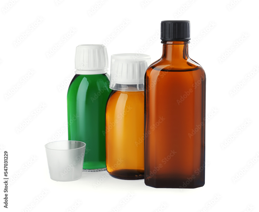 Bottles of syrups with measuring cups on white background. Cough and cold medicine