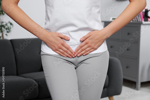 Woman suffering from cystitis at home, closeup