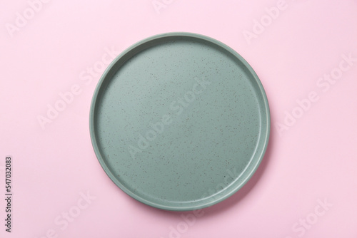 Empty grey ceramic plate on pink background, top view