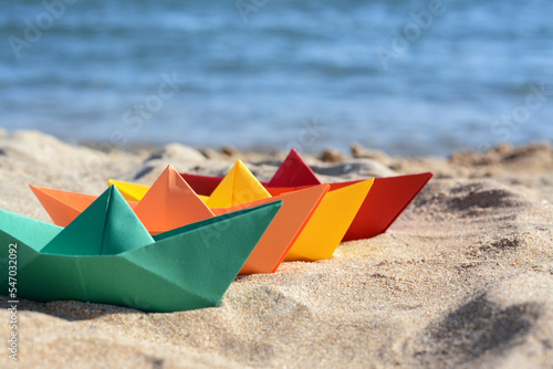 Many paper boats near sea on sunny day. Space for text