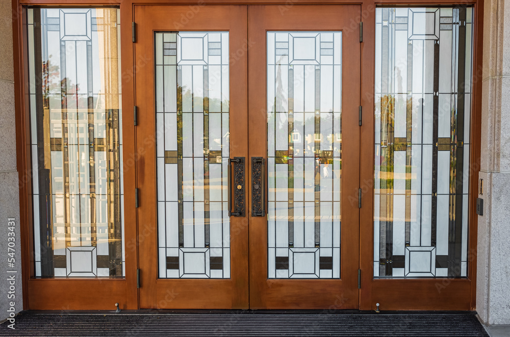 Stain glass door. Front Entrance of a traditional house with mission style stained wood door. Glass front door Stain glass door. Front Entrance of a traditional house with mission style stained wood door. Glass front door