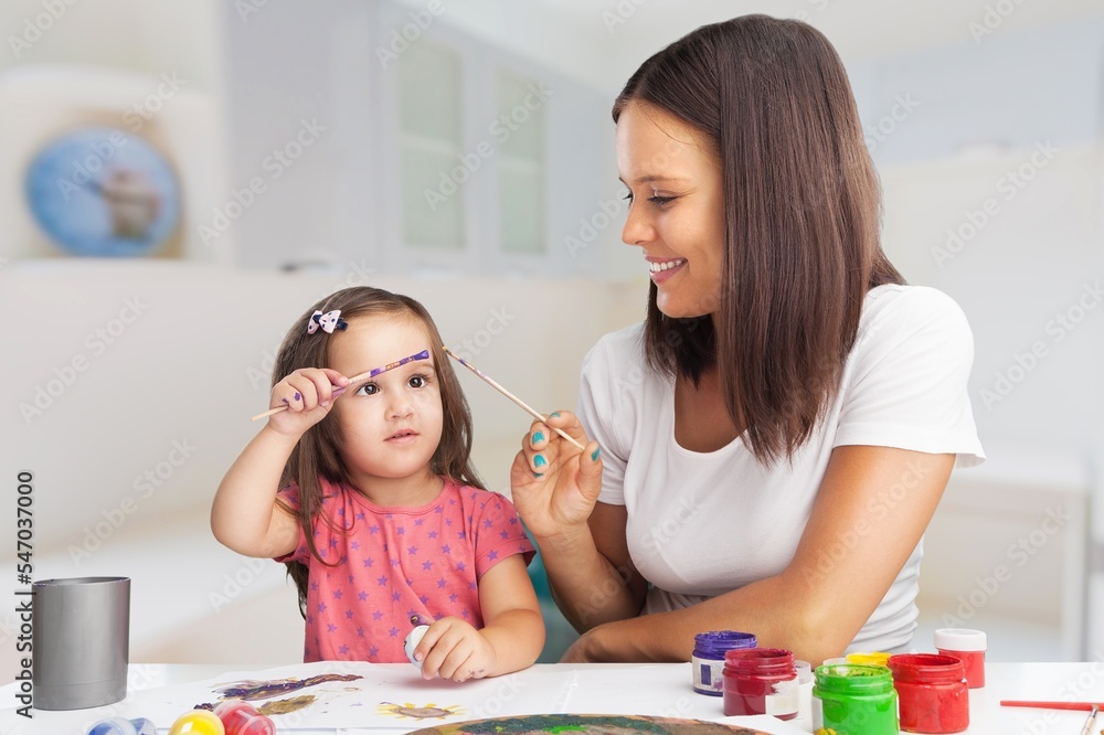 Little child with a young tutor or mother do homework Little child with a young tutor or mother do homework