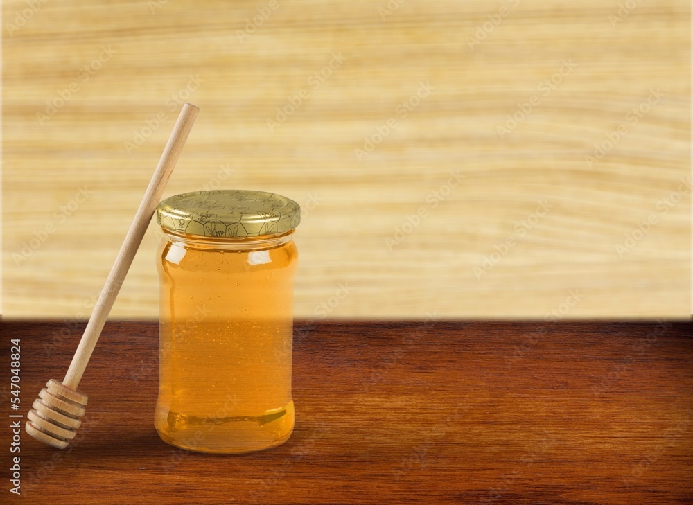 Oil or honey in jar on wooden desk Oil or honey in jar on wooden desk