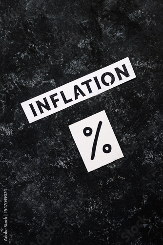 Inflation text with percentage symbol on dark background, economic struggles after the pandemic