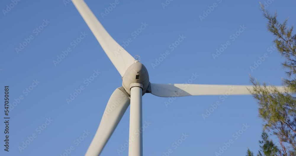 White wind turbine spin over the blue sky White wind turbine spin over the blue sky