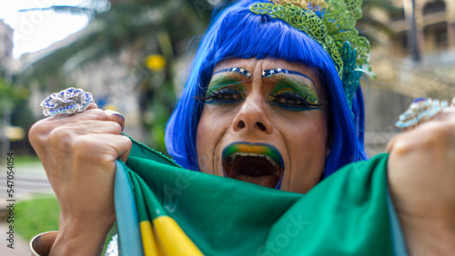 Dragqueen in her green and yellow outfit and makeup cheering during the world cup
