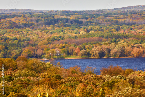 A calm lake on a beautiful fall day with trees turning colors from a high scenic angle near Hudson Wisconsin USA