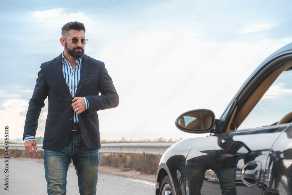 Elegant, bearded and handsome man walks to his car Elegant, bearded and handsome man walks to his car