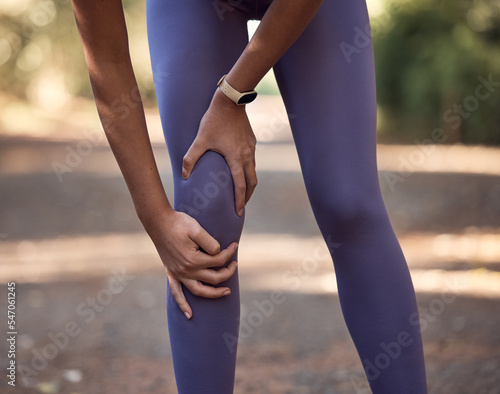 Knee pain, injury and accident of a woman training for a running marathon, race or competition in nature. Sprain bone, injured leg and swollen muscle of athlete doing cardio exercise on outdoor trail