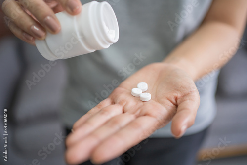 Billede på lærred Female patient pouring pills from painkiller bottle in hand, health care, receiv
