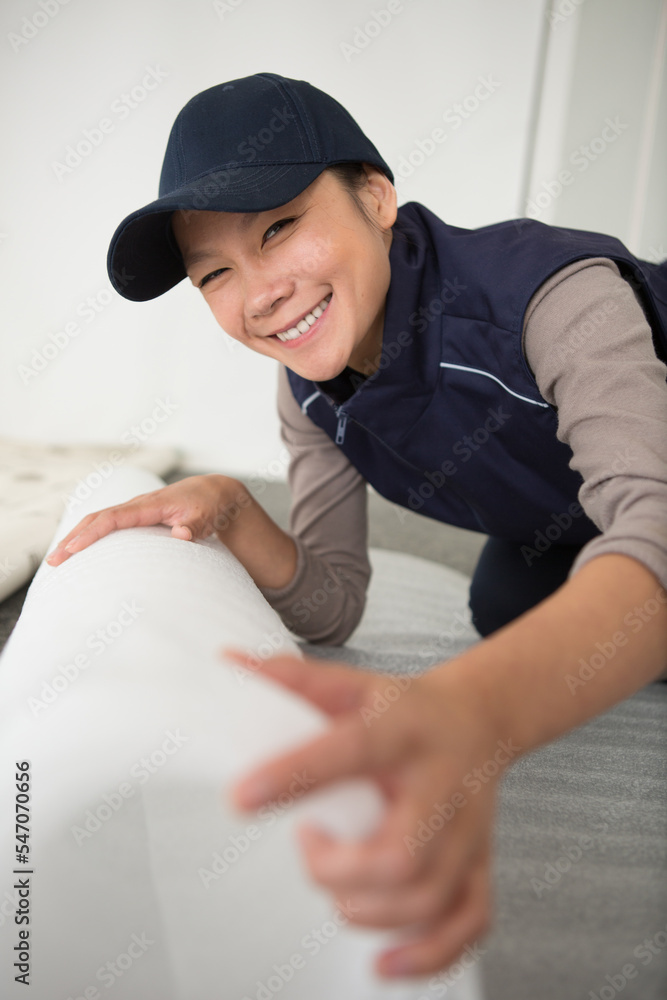 Obraz premium professional female worker rolling carpet
