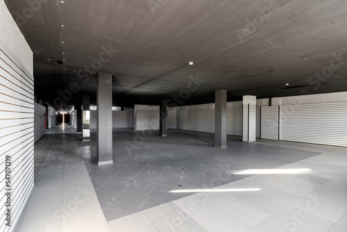 Empty retail space with a black ceiling and a dirty floor, immediately after repair