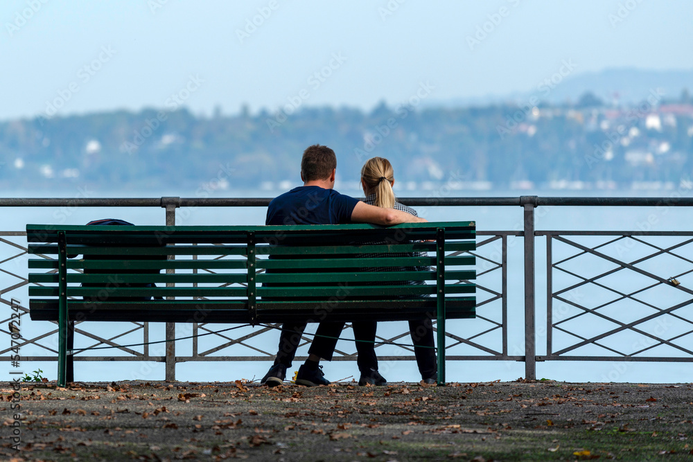 Couple assis sur un banc face au lac de Genève en Suisse