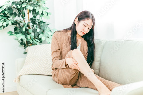 脚のむくみに悩みフットケアする日本人女性
 photo