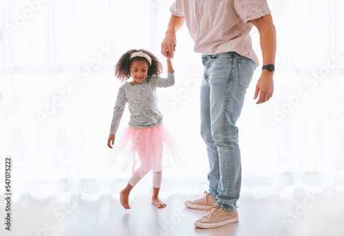 Family, love and father dance with girl, having fun and bonding in home. Smile, happy and parent with child or kid holding hands, playing and dancing, care or enjoying quality time together in house