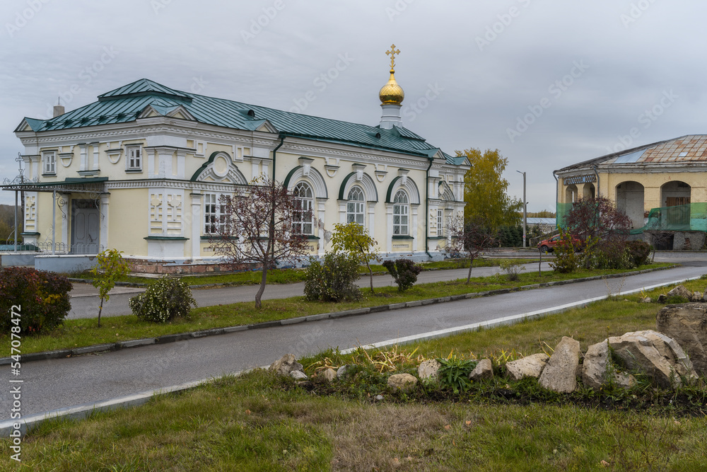 Well-groomed square with an openwork church in the center of ancient Kungur (Urals, Russia) in autumn.