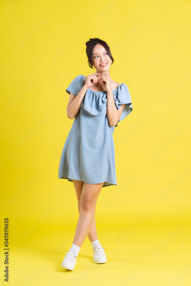 portrait of Asian woman in skirt posing on yellow background portrait of Asian woman in skirt posing on yellow background
