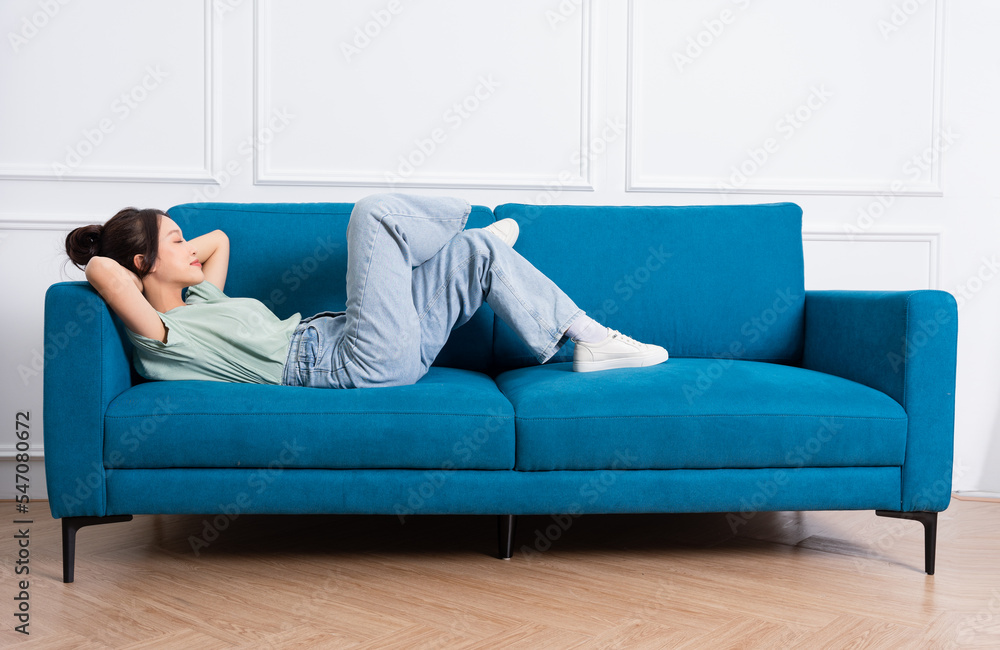 Obraz premium image of young Asian girl sitting on sofa at home
