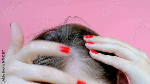Girl touching her hair close-up on pink background , hair loss concept.