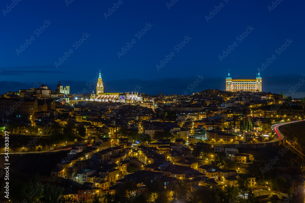 Night photo of the city of Toledo in Spain. Toledo Cathedral and Alcazar de Toledo illuminated. Night photo of the streets and main monuments of Toledo in Spain. Historic buildings of Spain.