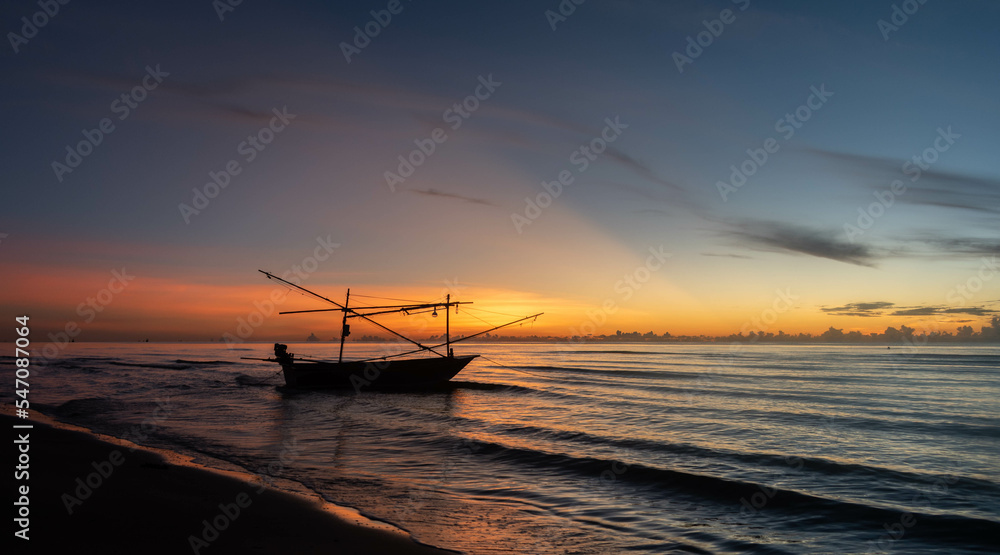 seascape in sunrise time with silhouette boat and skyline