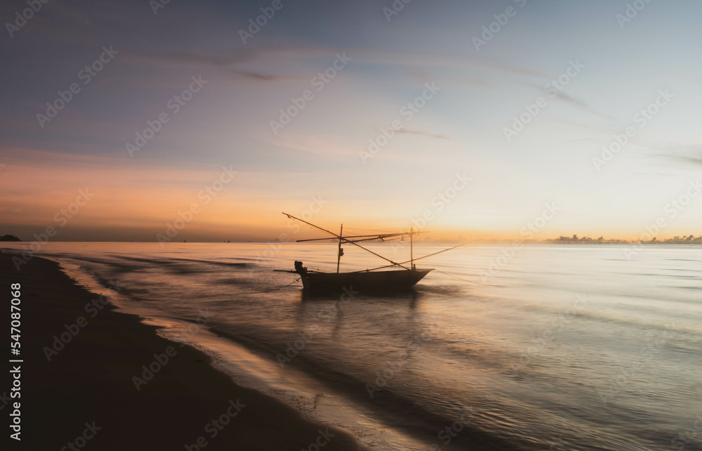 seascape in sunrise time with silhouette boat and skyline