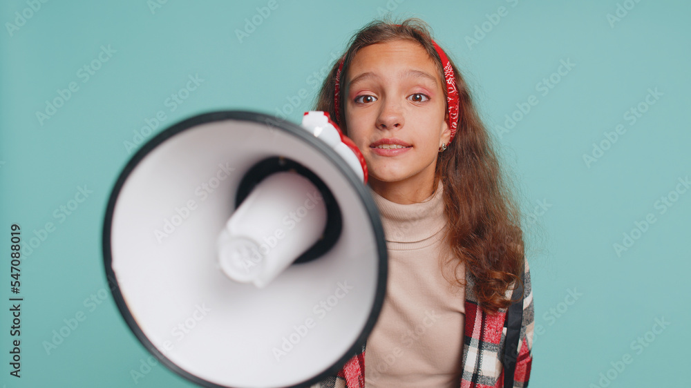 Hurry up. Young teenager child girl kid talking with megaphone, proclaiming news, loudly announcing advertisement, warning using loudspeaker to shout speech. Preteen children on studio blue background Hurry up. Young teenager child girl kid talking with megaphone, proclaiming news, loudly announcing advertisement, warning using loudspeaker to shout speech. Preteen children on studio blue background
