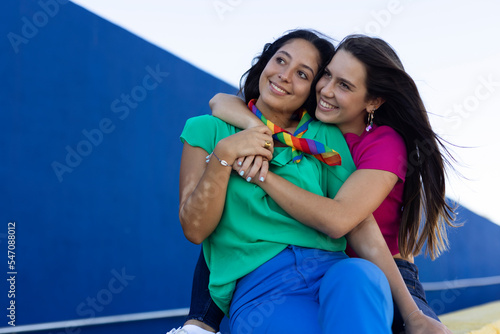 Beautiful lesbian young couple embraces. Two girls enjoy outside.