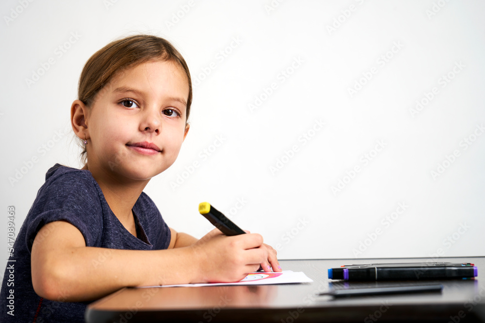 Little girl drawing rainbow at desk, csloe-up Little girl drawing rainbow at desk, csloe-up