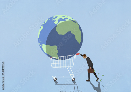 Businessman investor pushing large globe in shopping cart
 photo