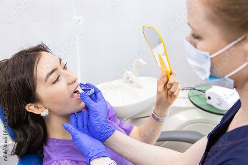Dentistry concept. Professional dental services and modern equipment without pain. The doctor consults and treats the young woman  conducts an examination and prepares for the installation of veneers