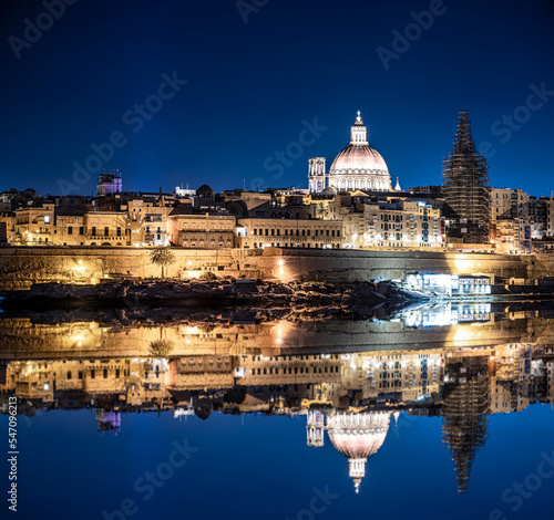 Illuminated at night harbor of Valletta old town with reflection in sea. Night Valletta. City center.