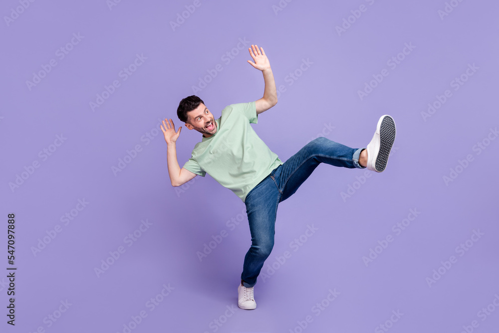 Full length photo of crazy astonished man wear trendy clothes jeans look up empty space afraid scared isolated on purple color background