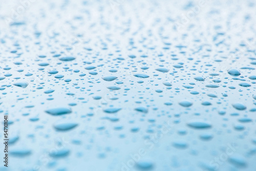 close up of small drops of rainwater or condensation on a reflective blue mettalic surface. Freshness texture background