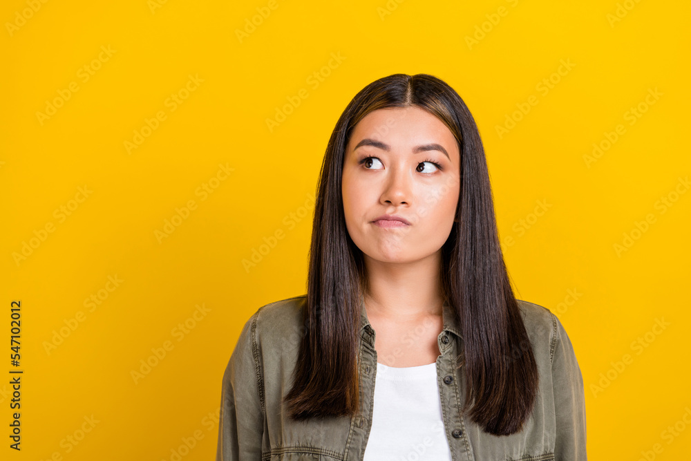 Portrait of good mood thoughtful girl with long hairstyle dressed khaki shirt look empty space isolated on yellow color background Portrait of good mood thoughtful girl with long hairstyle dressed khaki shirt look empty space isolated on yellow color background