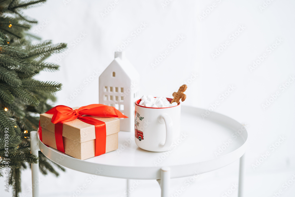 Christmas still life of present gift box, cocoa with marshmallow on white table Christmas still life of present gift box, cocoa with marshmallow on white table