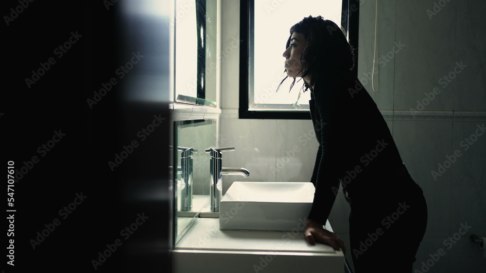 Troubled young woman standing in front of bathroom mirror suffering from mental disorder Troubled young woman standing in front of bathroom mirror suffering from mental disorder