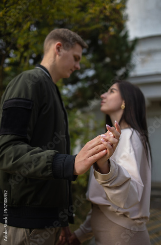 Man and a woman hold hands selectively focus on their hands. Hands in focus. Young couple in out of focus. Concept: date, couple. dating, dating app, singles, healthy attitudes © Елена Бабанова