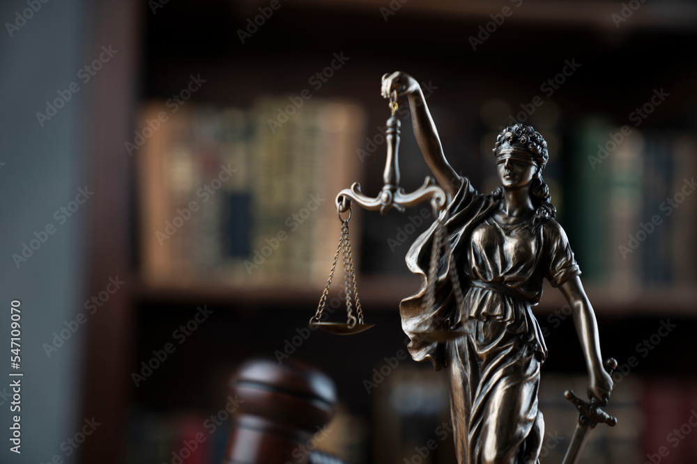 Lawyer office. Judge’s gavel, Themis sculpture and legal books in the bookshelf. Lawyer office. Judge’s gavel, Themis sculpture and legal books in the bookshelf.