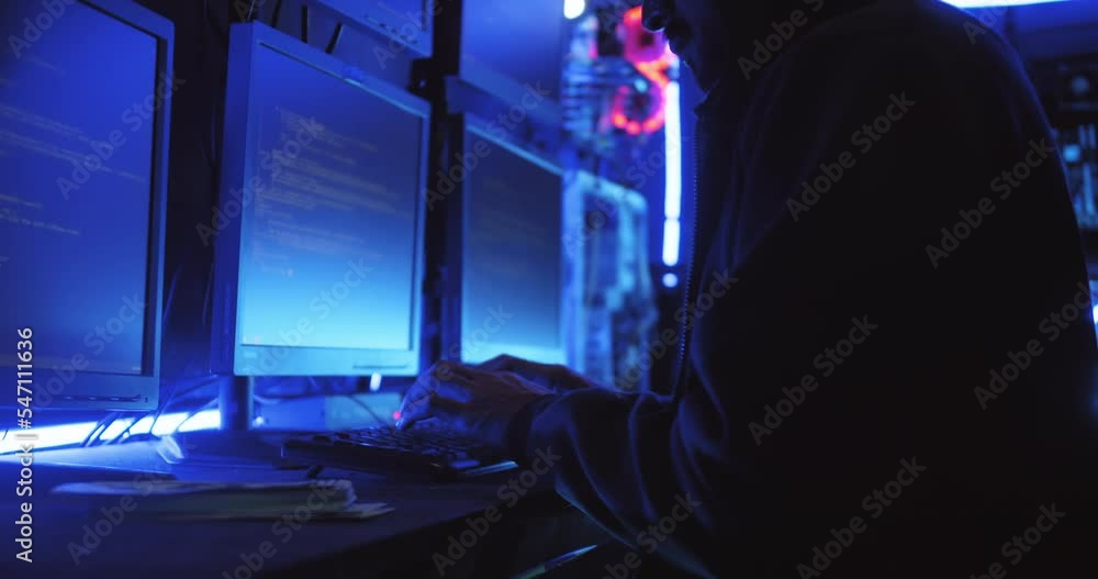 A male hacker is using a computer to hack data to demand ransom from victims. A male hacker is using a computer to hack data to demand ransom from victims.