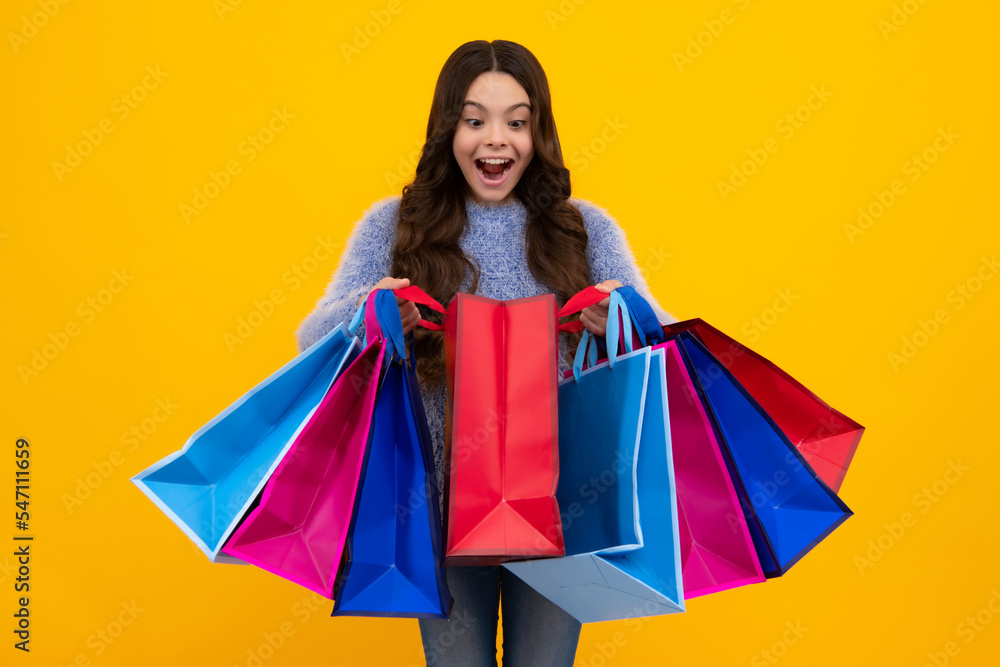 Amazed teenager. Sale and shopping concept. Teen girl holding shopping bags, isolated on studio background. Excited teen girl.
