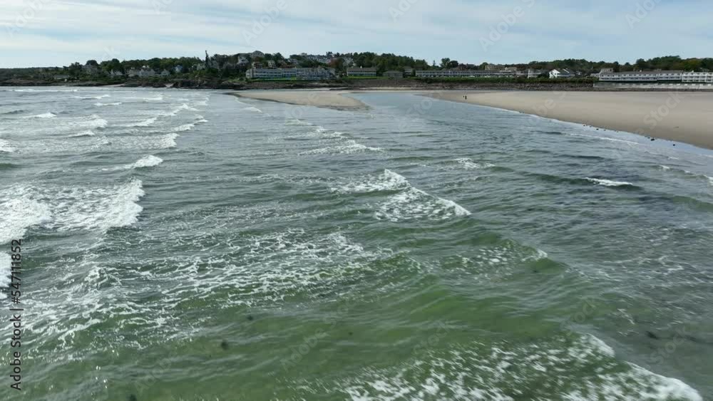 New England ocean with building on horizon. Aerial above crashing waves of Atlantic. New England ocean with building on horizon. Aerial above crashing waves of Atlantic.