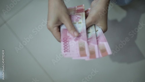 woman hand showing rupiah Indonesian money photo