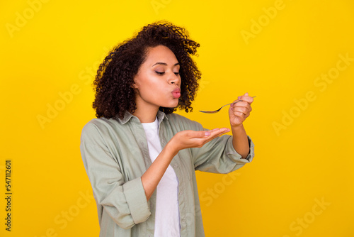 Profile photo of nice wavy young brunette lady try food wear grey shirt isolated on yellow color background