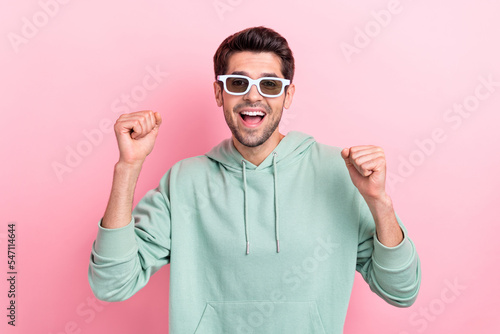 Photo of astonished satisfied person raise fists celebrate shout yes isolated on pink color background © deagreez