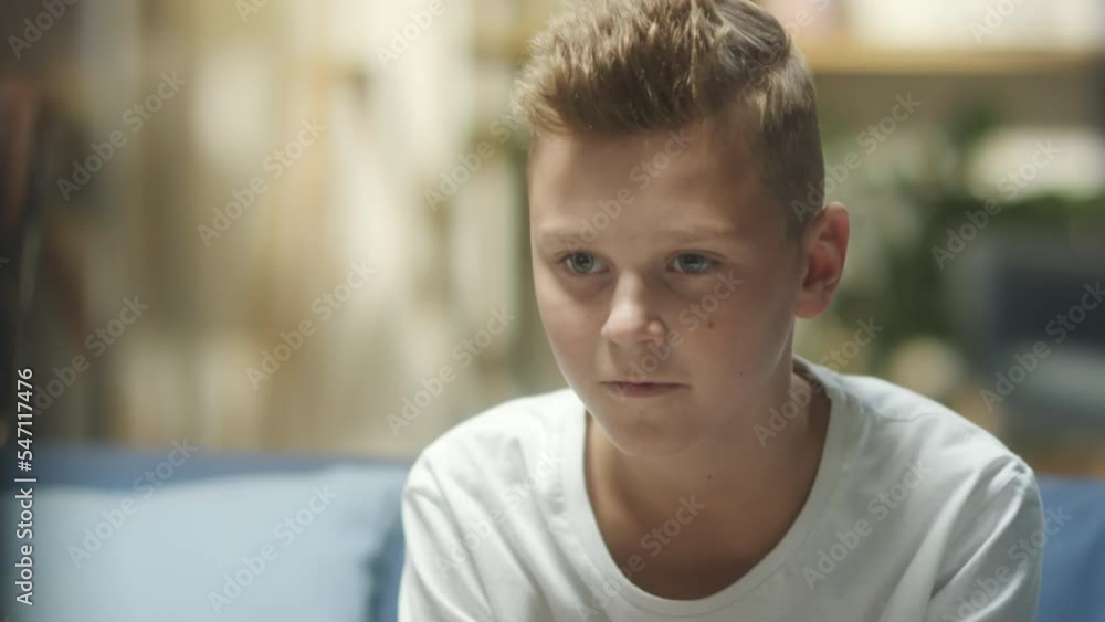 Close up shot of excited teen boy sitting on sofa at home and playing video game on TV Close up shot of excited teen boy sitting on sofa at home and playing video game on TV