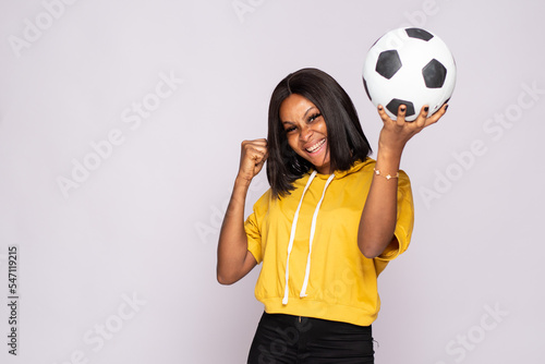 excited young black man holding a soccer ball rejoicing photo