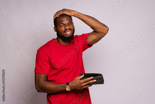 broke african man holding an empty wallet photo