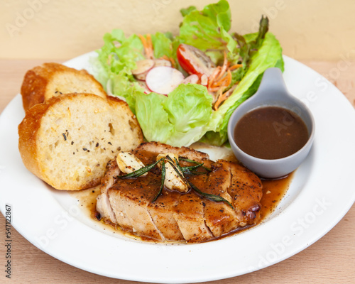 Pork sirloin steak with gravy sauce, salad and garlic bread