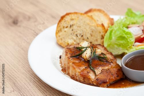 Pork sirloin steak with gravy sauce, salad and garlic bread